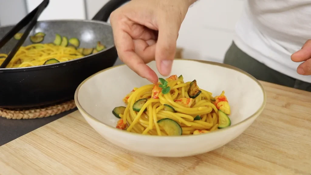 decorar pasta de gambas y calabacín con hojas de menta
